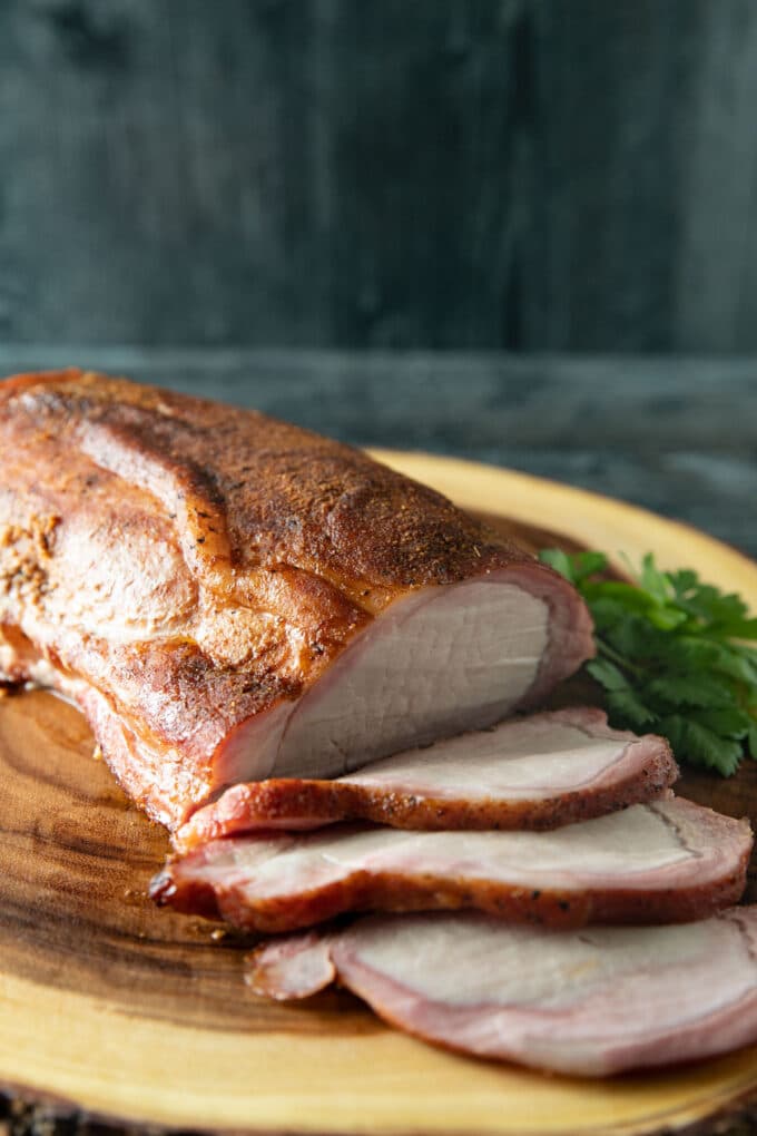 Sliced pork loin on a tree slab.