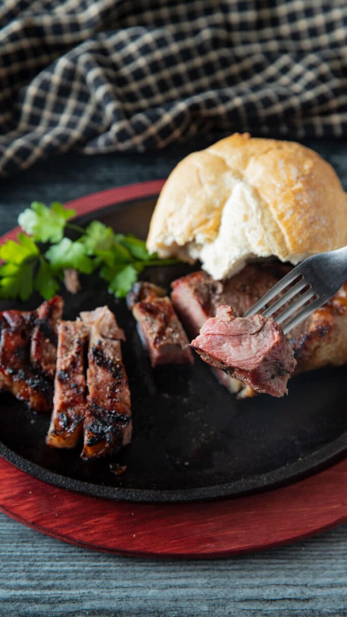 Sliced smoked steak on cast iron skillet.