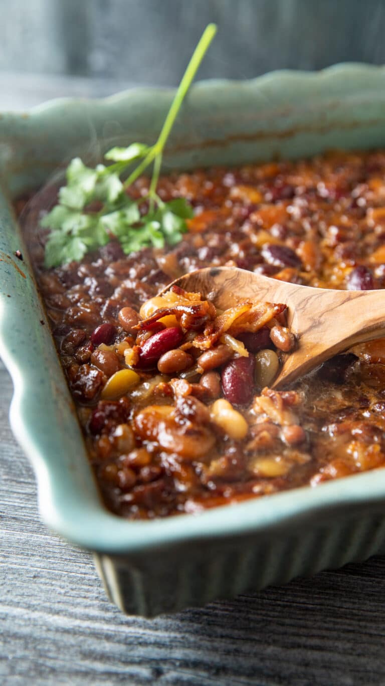 Large spoon scooping baked beans out of casserole.
