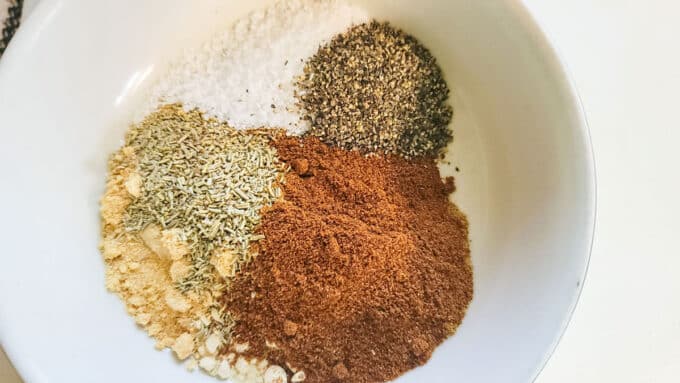 Dry rub ingredients added to a bowl.