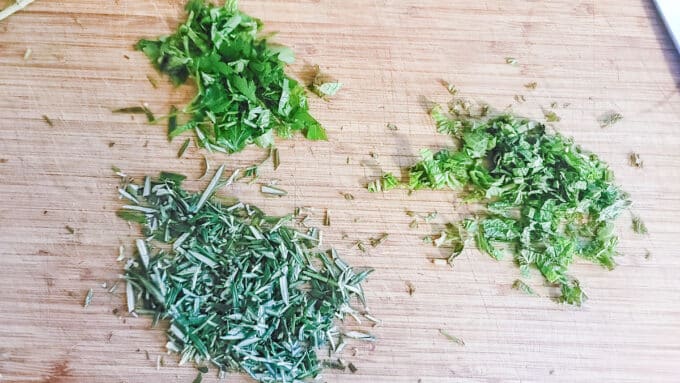 Fresh herbs chopped on a board.