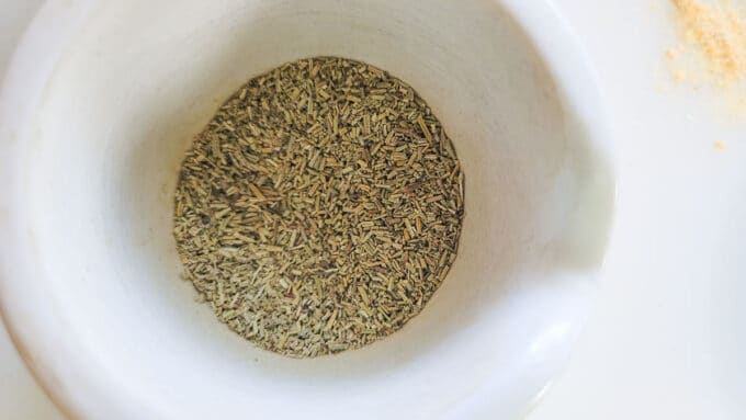 Ground up rosemary in a mortar.