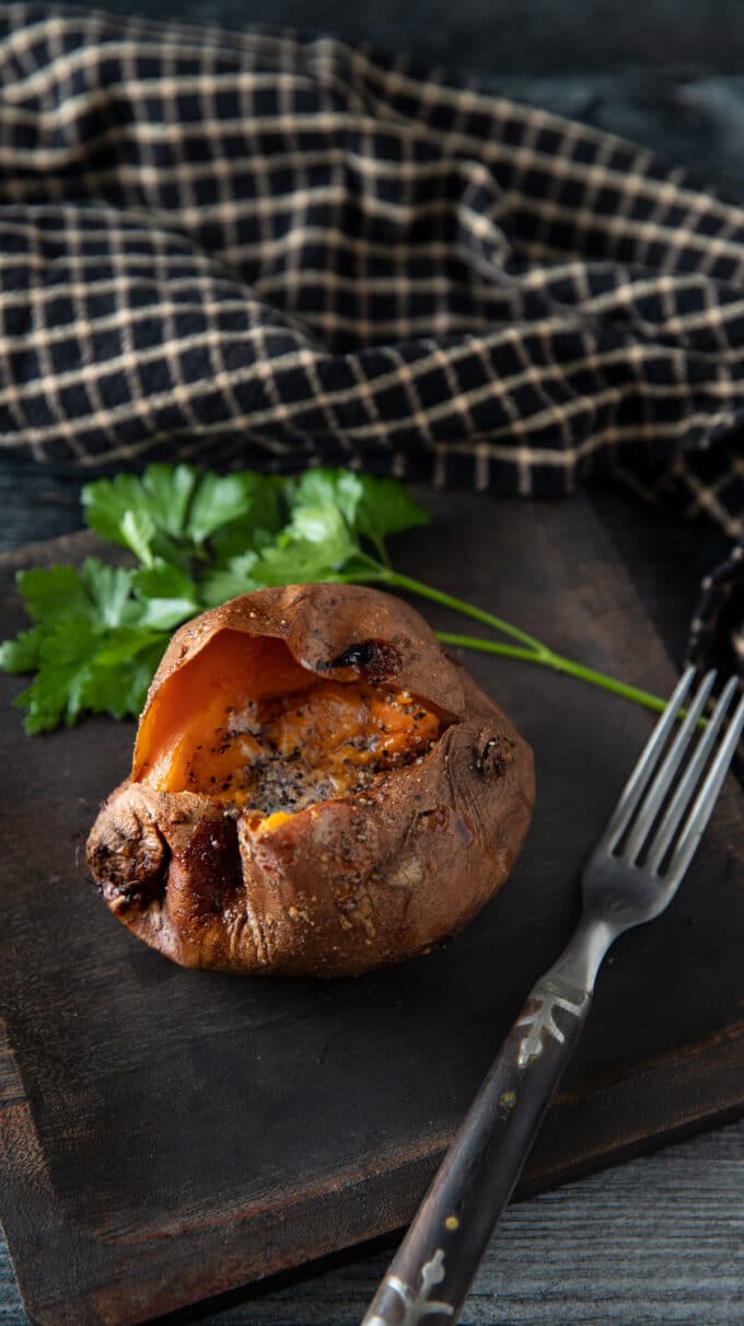 Sweet potato on a wooden plate with parsley.
