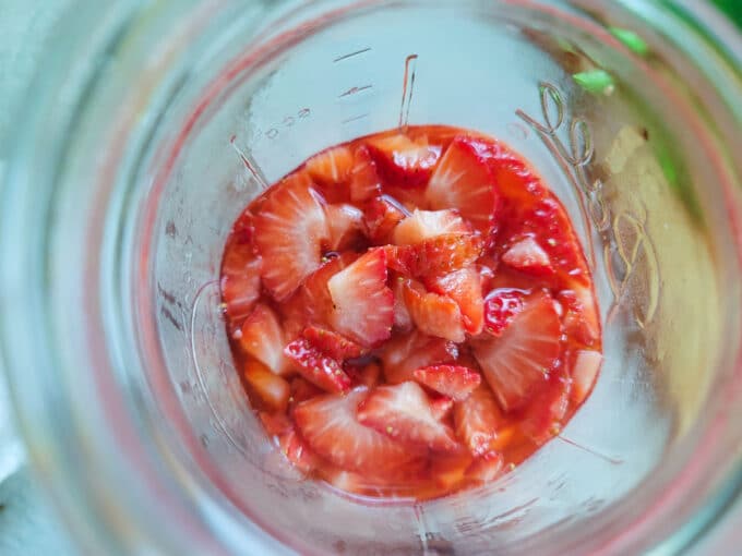 Chopped strawberries and vinegar in a jar.