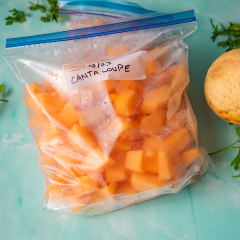 Bags of frozen cantaloupe on a blue background
