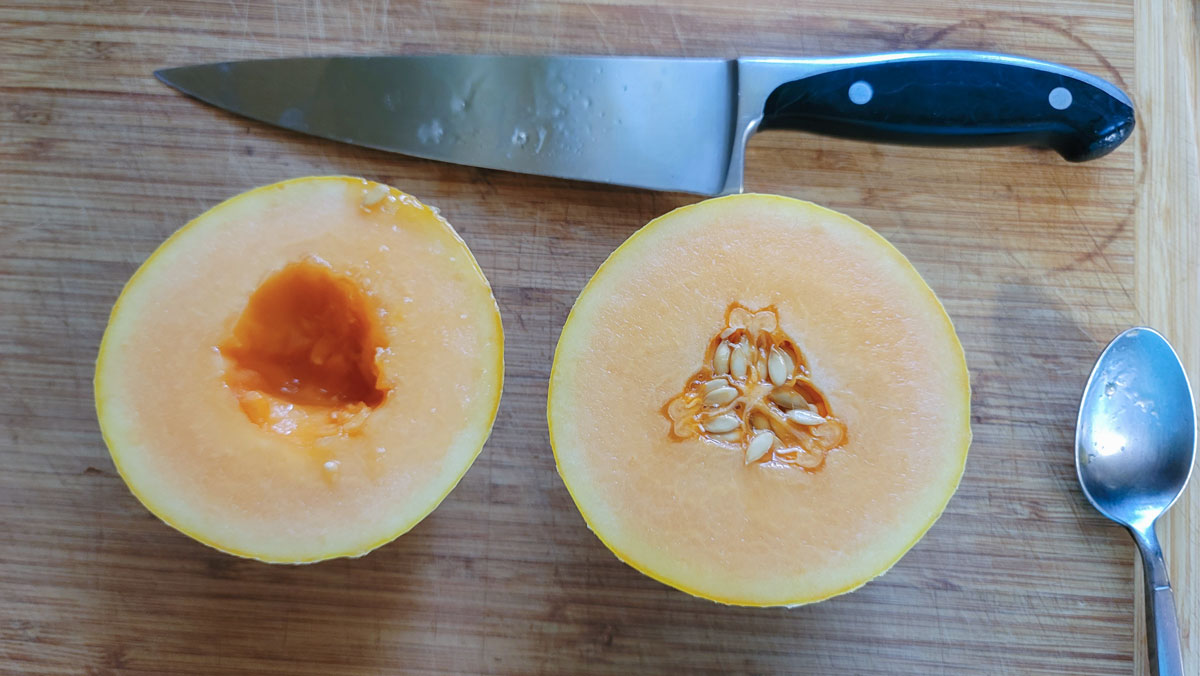 Melon cut in half with the seeds removed from one half.