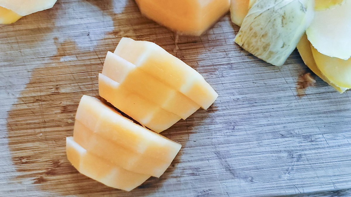 Sliced cantaloupe on cutting board.