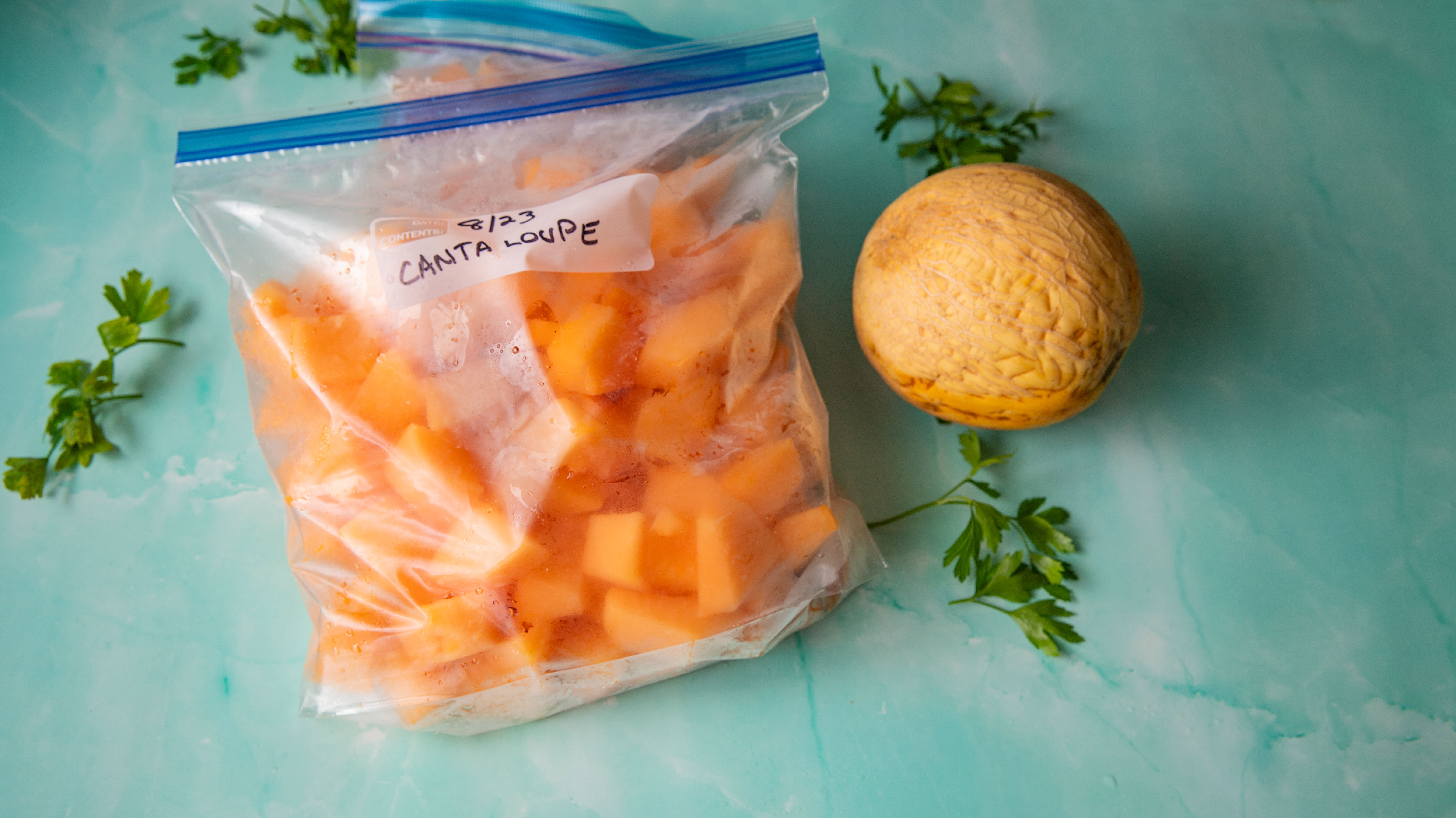 Frozen bags of melon with a whole melon.