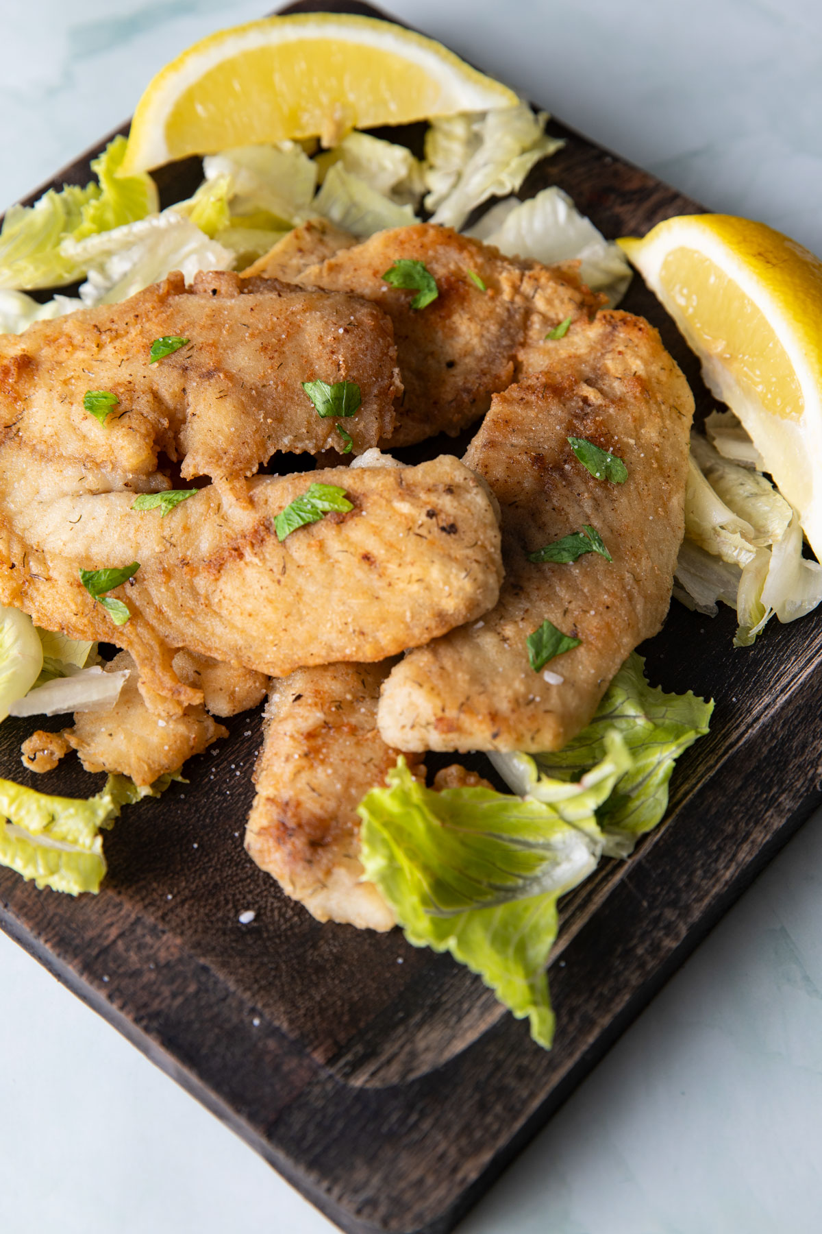 Fried fish on a wooden plate.