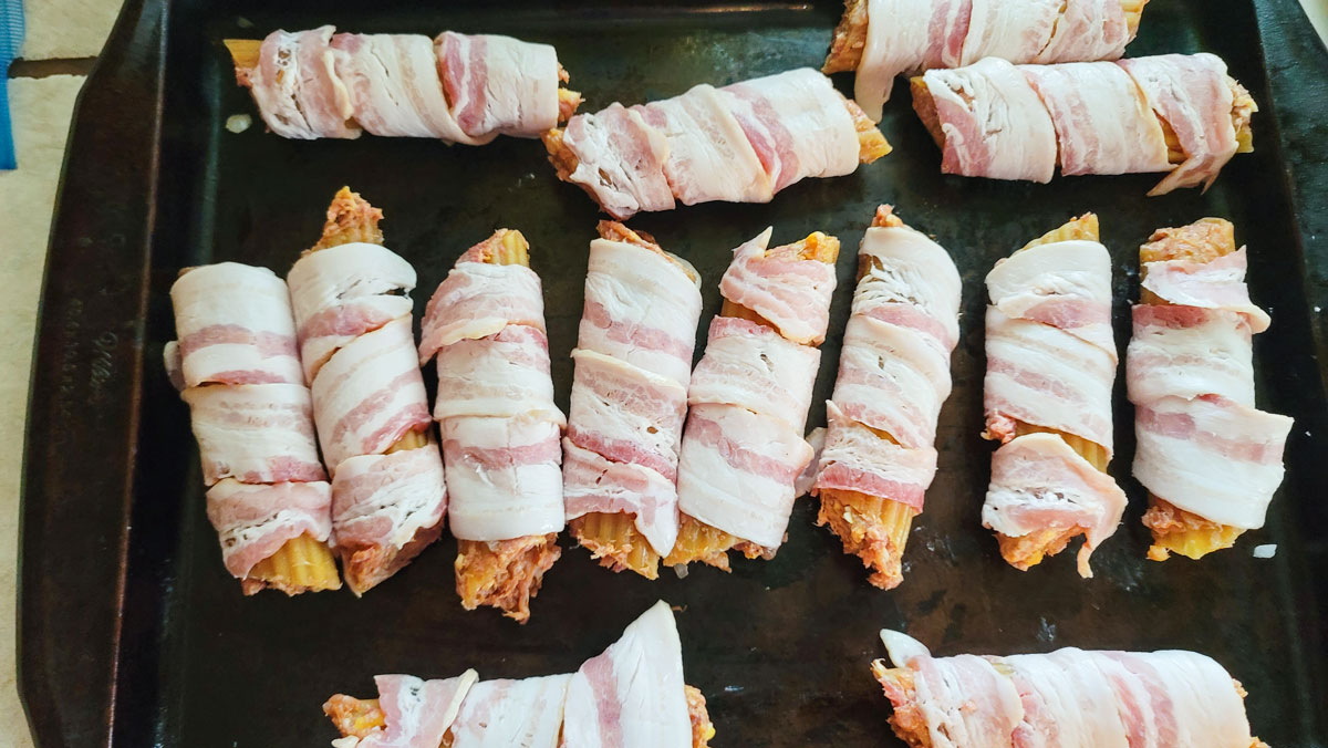 Bacon wrapped shells on baking dish.