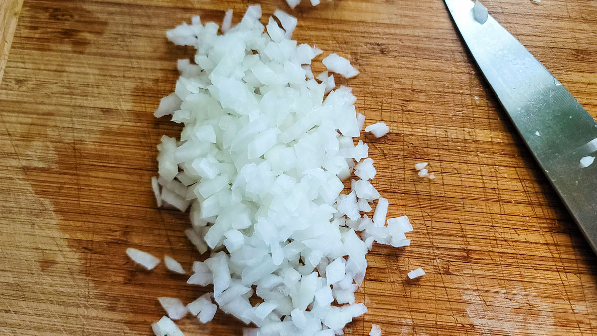 Chopped onions on a cutting board.