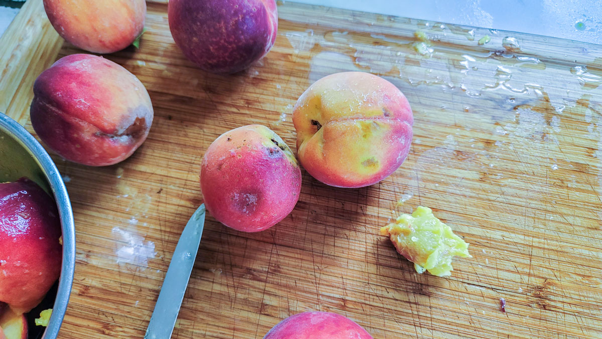 Cut peaches on a cutting board.