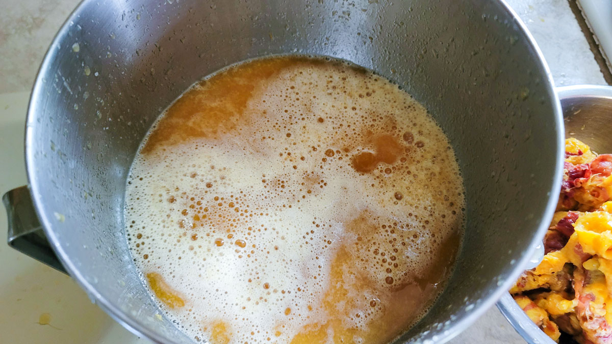 Peach juice in a large metal bowl.