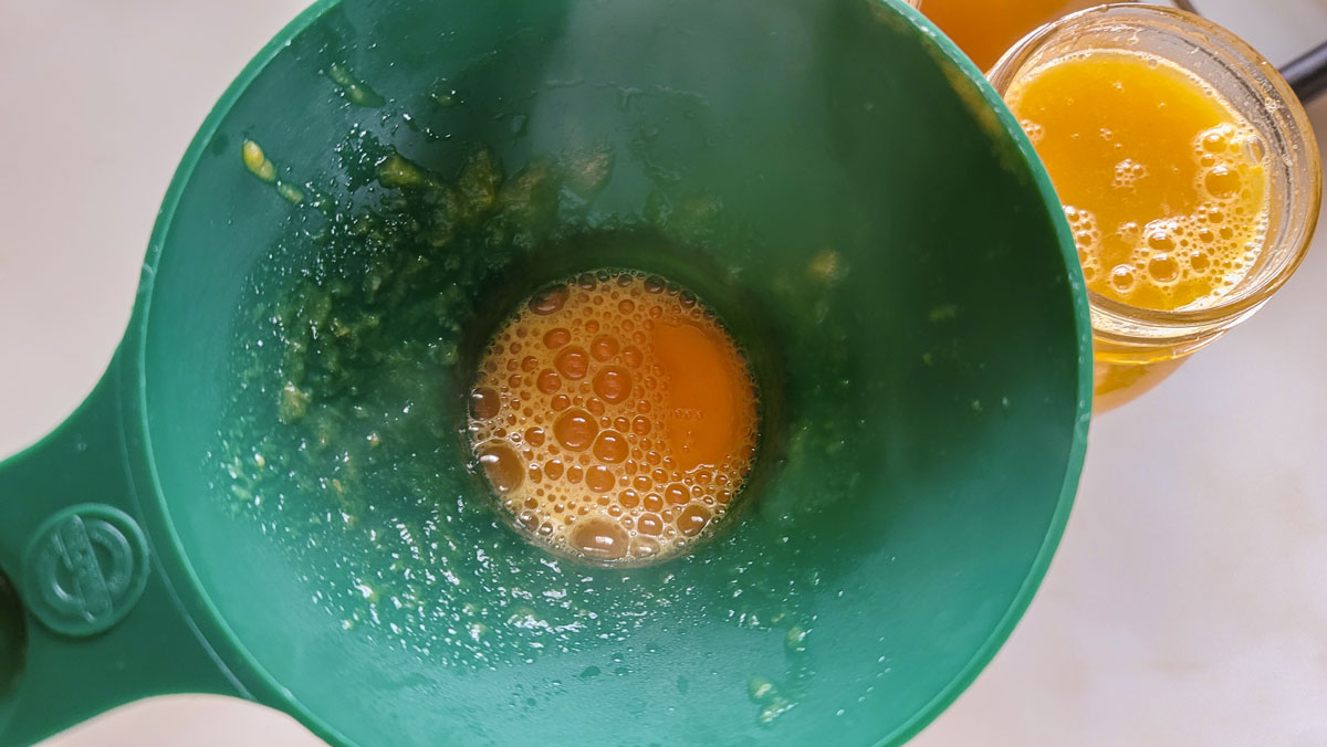 Canning funnel on a jar of peach juice.