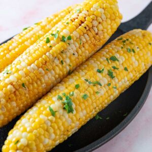 Stacked corn on the cob on a cast iron pan.