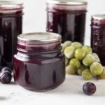 Jars of grape jelly with fresh grapes
