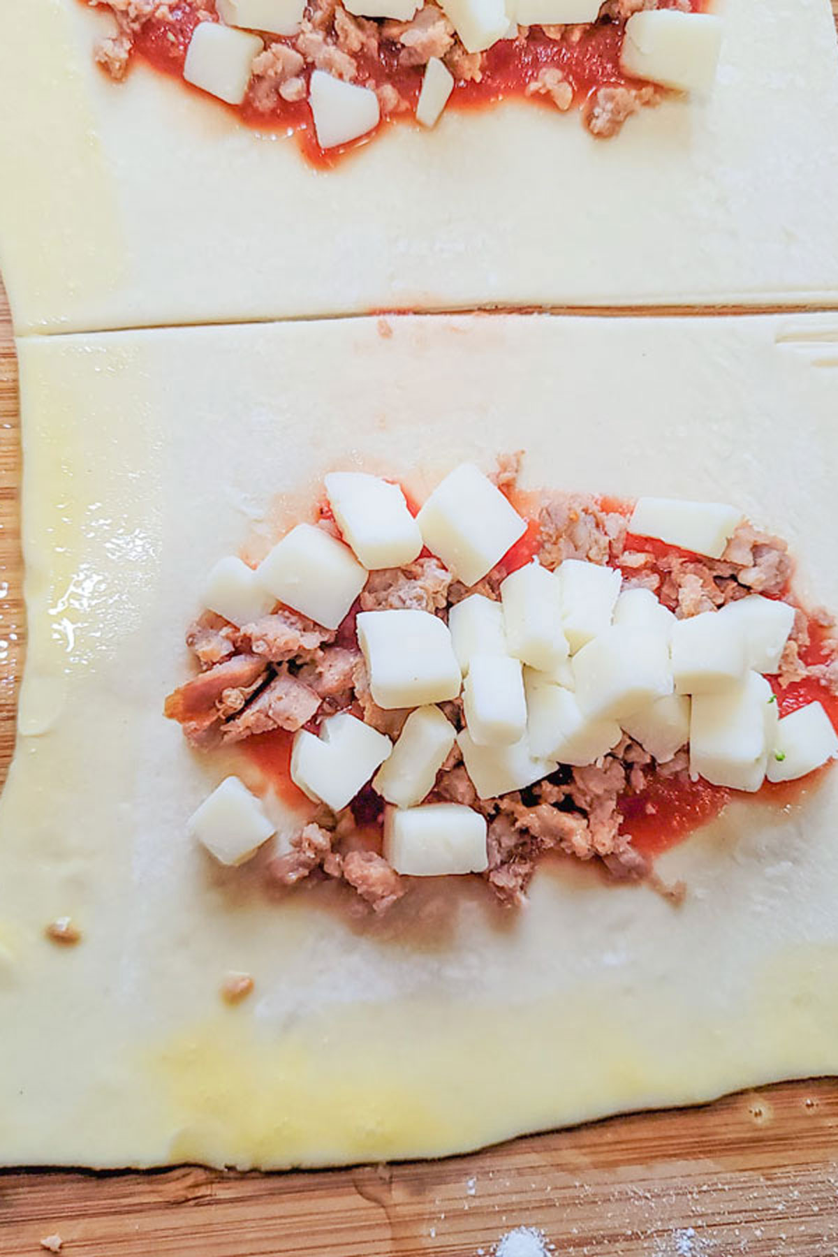 Cheese added on top of dough. Sides brushed with egg wash.