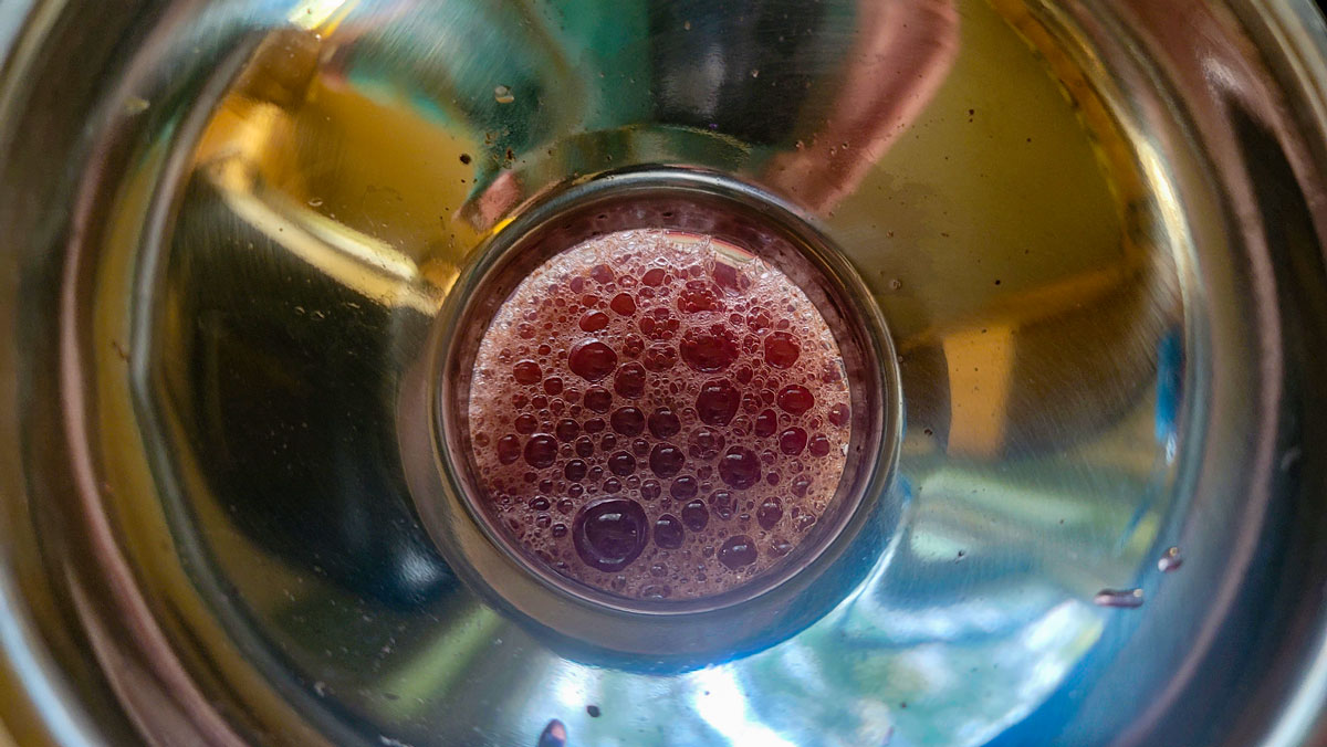 Filling the jar with juice with the aid of a canning funnel.