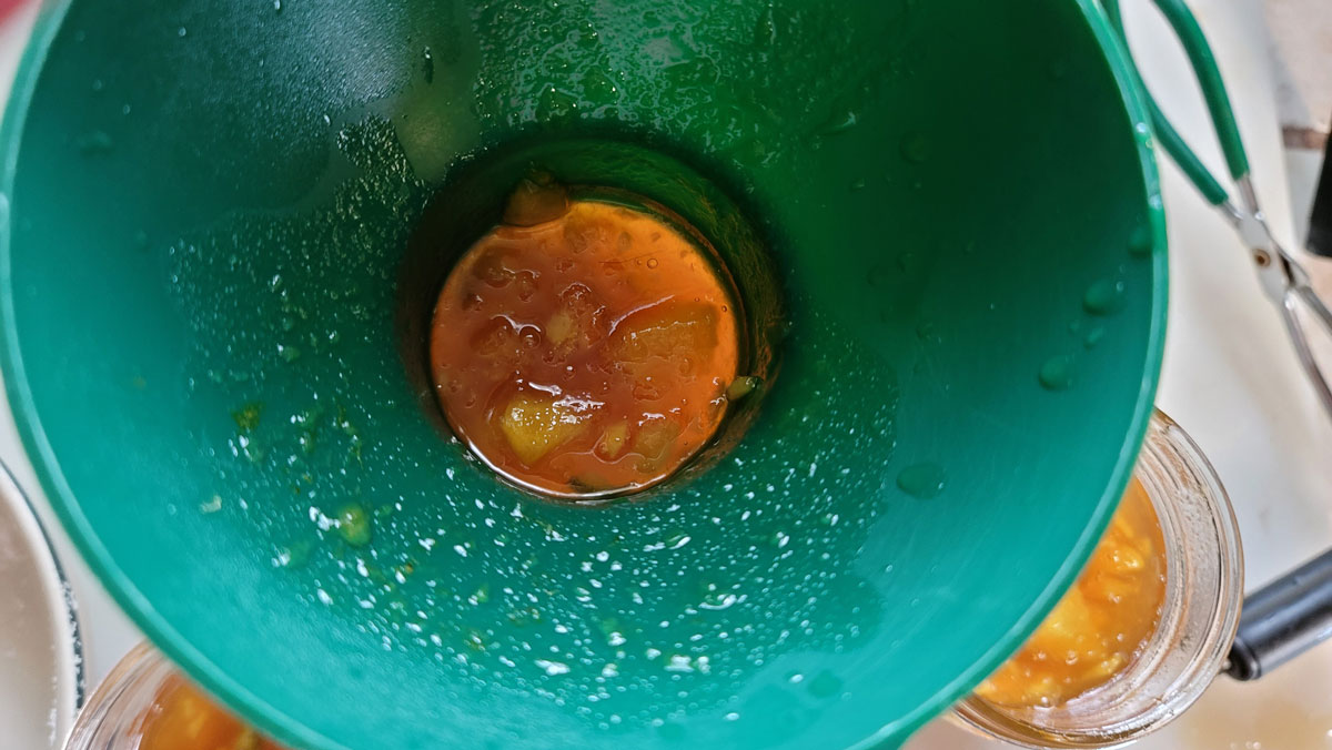 Filling jars with a canning funnel.