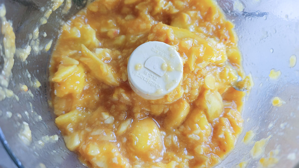 Peaches chopped in a food processor bowl. 