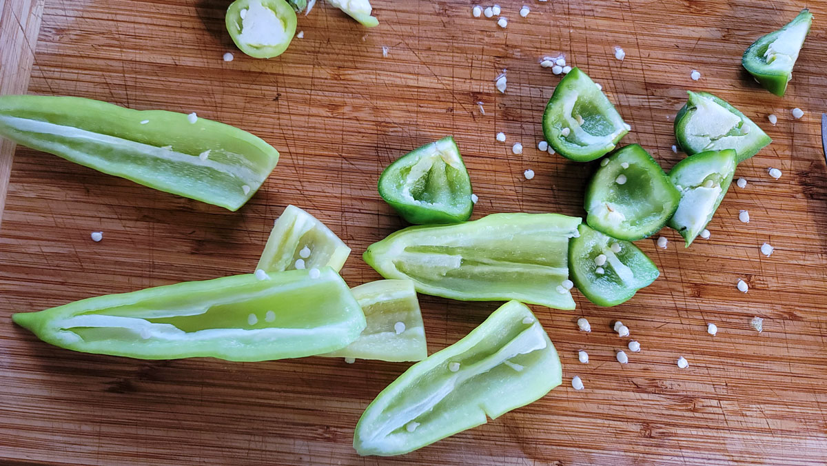 Peppers cut in half and deseeded on a cutting board.