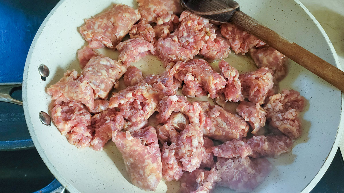Browning the sausage in a skillet.