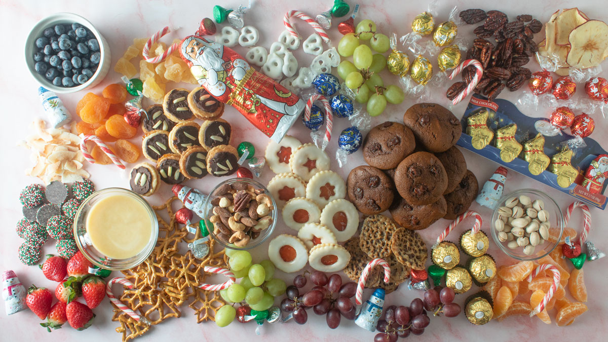 Mixed desserts on a large board with fruit and nuts.