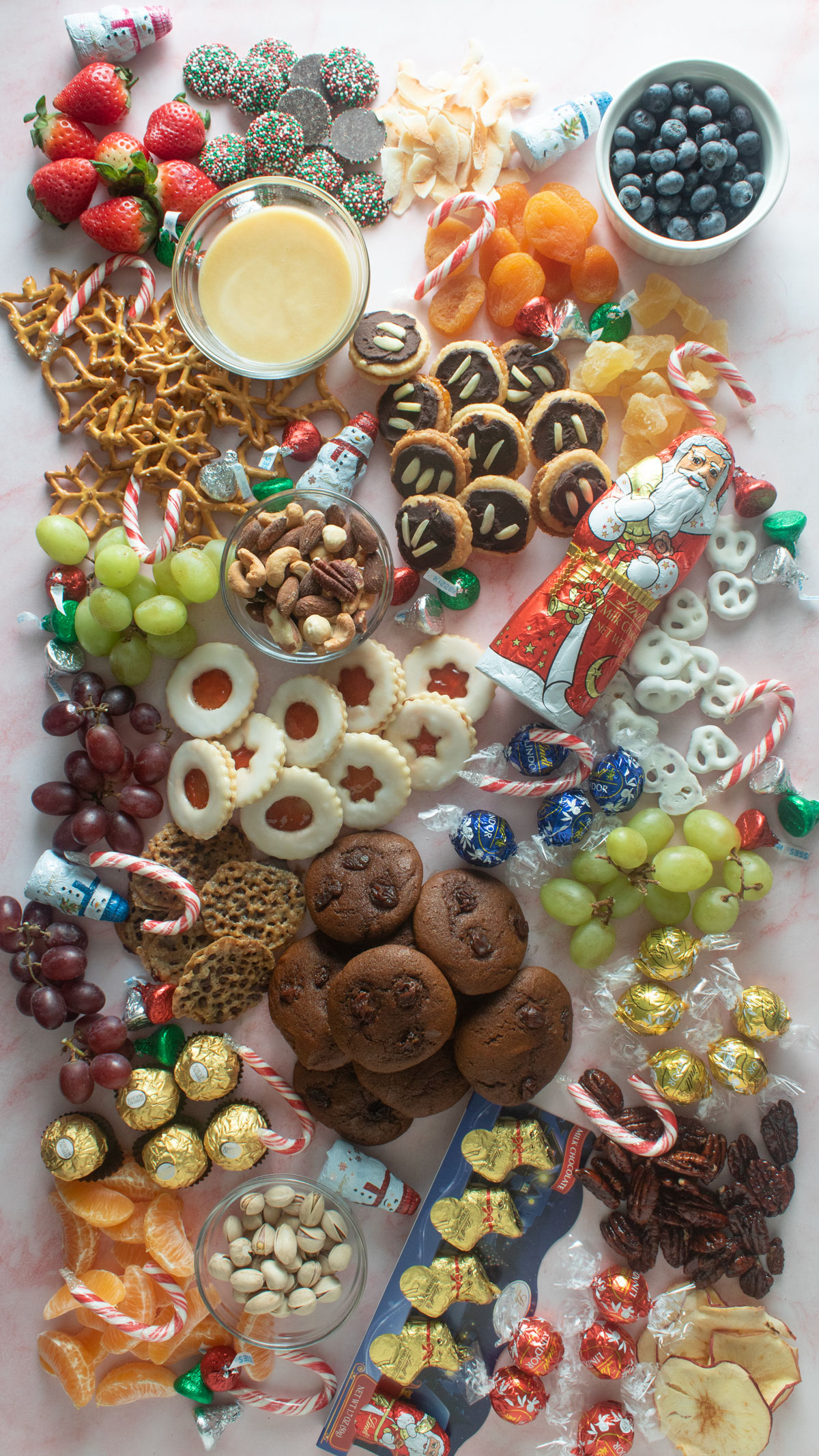 Colorful dessert charcuterie board with cookies, candies and fruit.