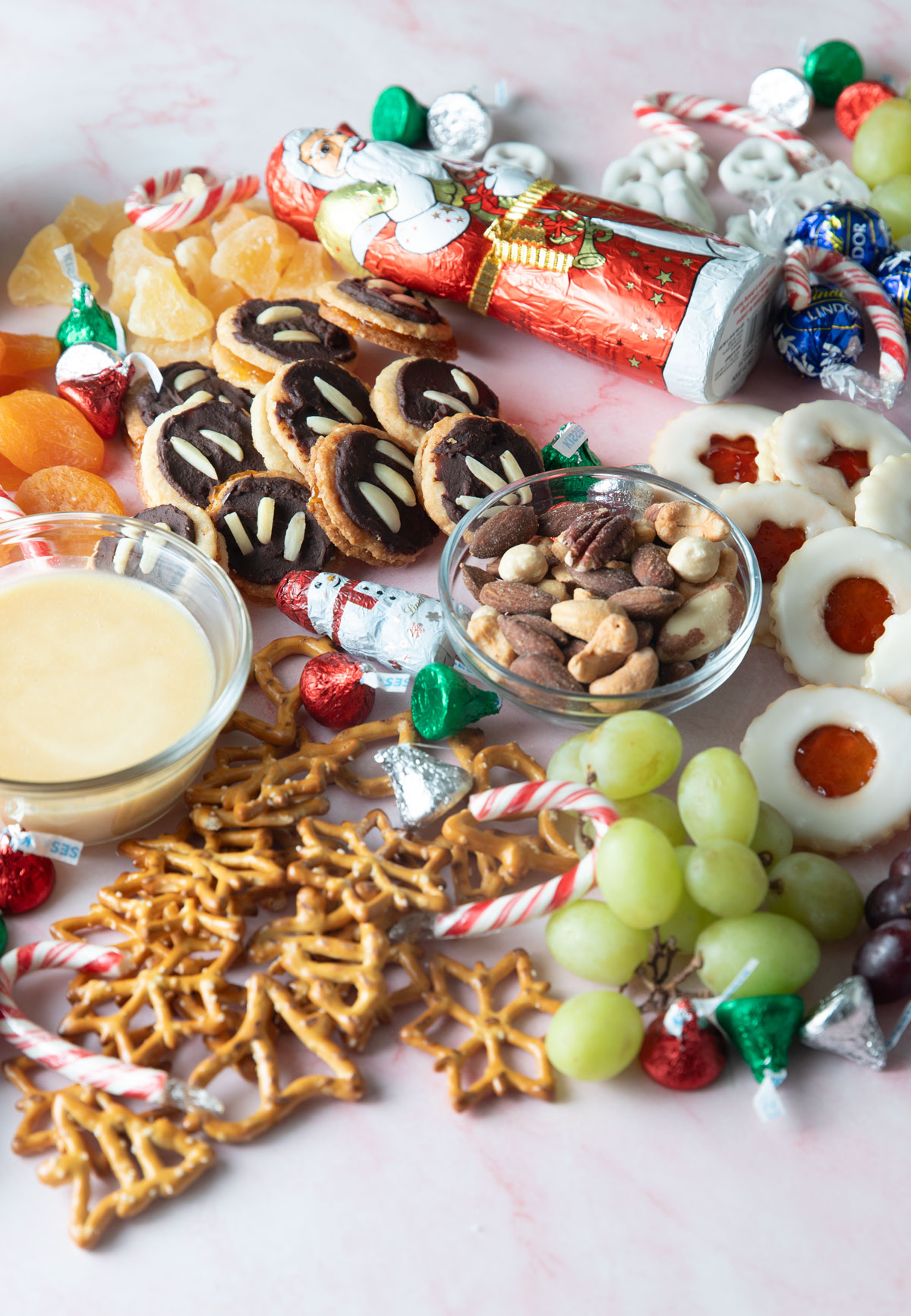 Close up of spitzbuben, Ischler, Christmas pretzels, and various fruit.