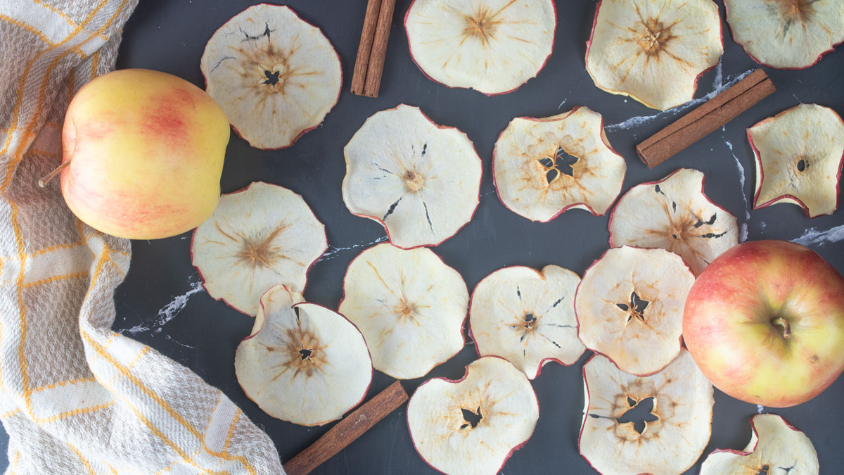 Dried apple chips on a black board.