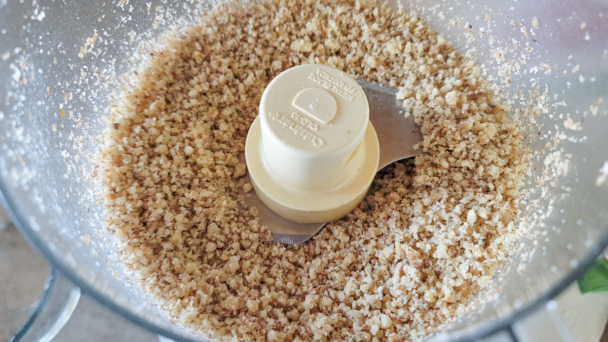 Ground nuts in a food processor bowl.