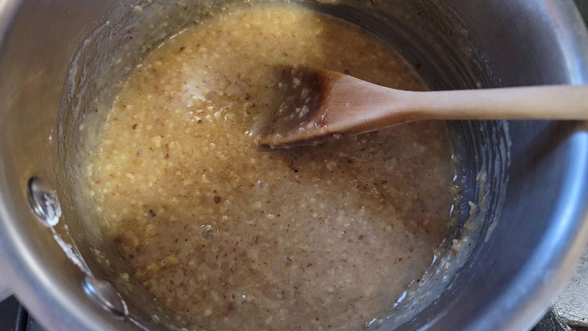 Blended ingredients form a dough in the saucepan.