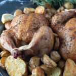 Cornish game hen with roasted potatoes.
