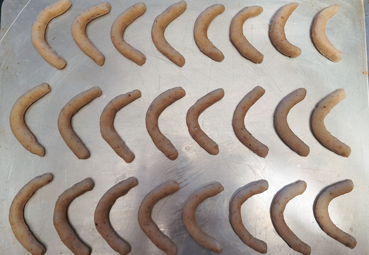 Crescent-shaped dough on a cookie sheet.