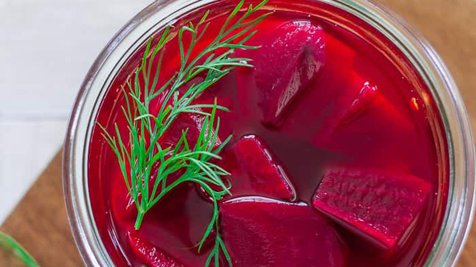 Pickled beets in a jar with a sprig of dill.