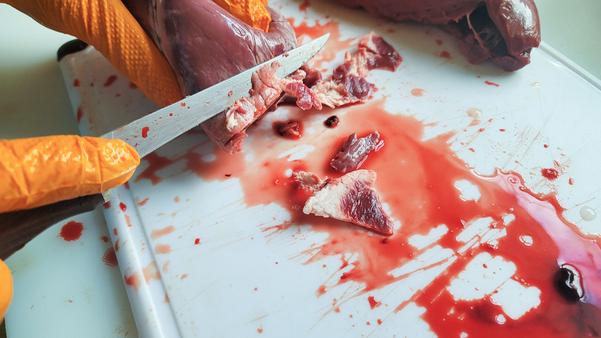 Cutting the fat off of the outside of the heart.