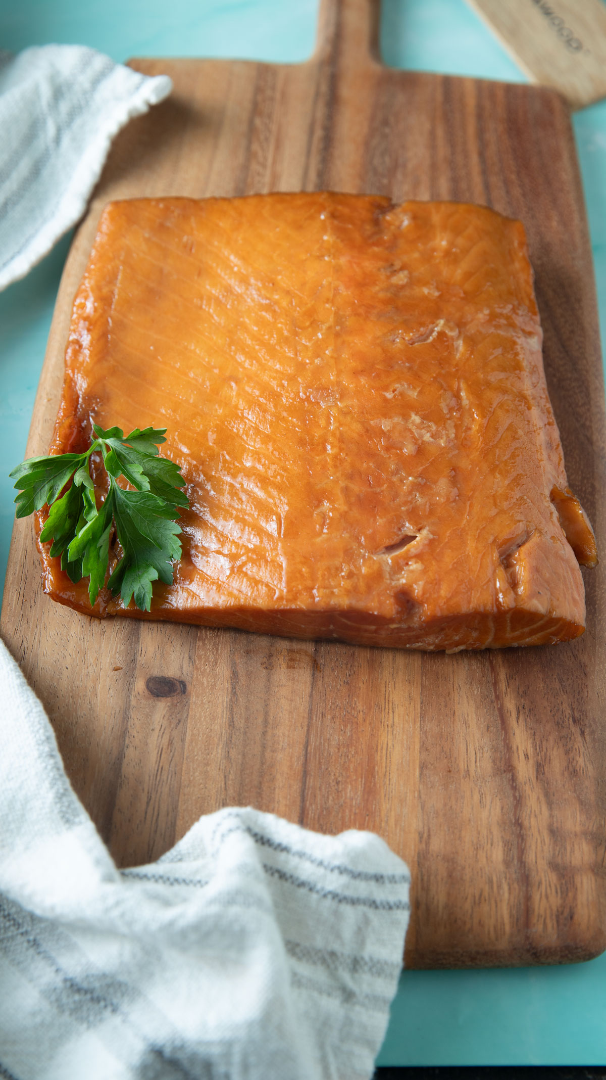 Slab of smoked salmon on a cutting board with handle.
