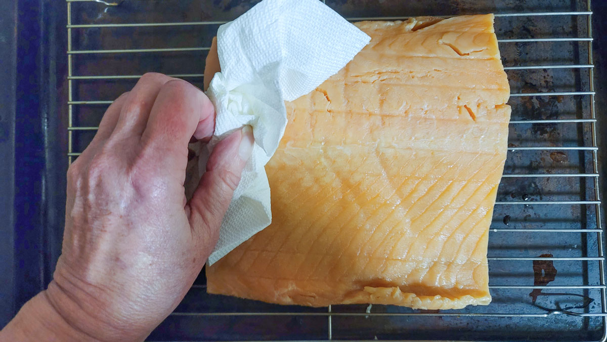 Drying off the filet with paper towel.