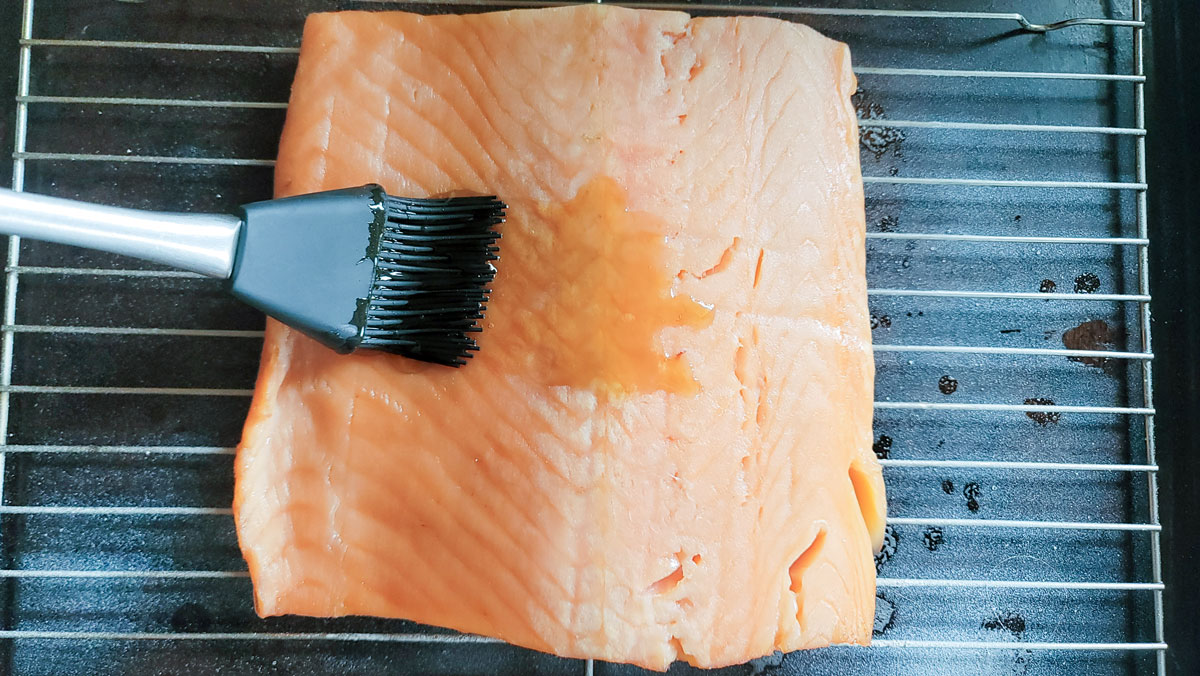 Basting the filet with maple syrup.