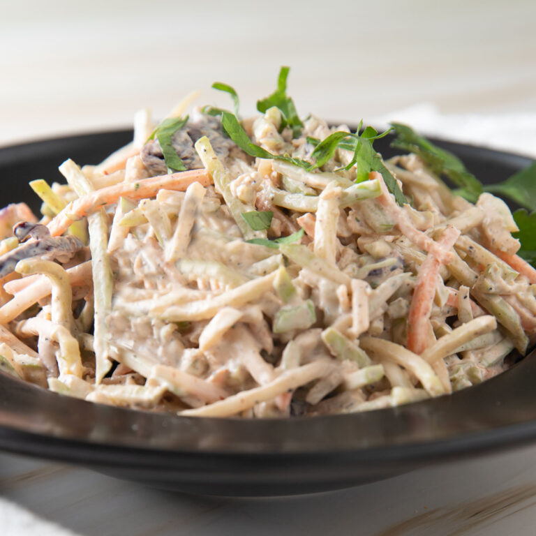 Spicy coleslaw in a black bowl.