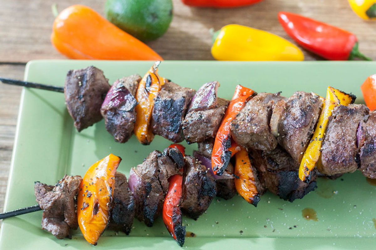 Two skewers with hunks of venison, red onion, red, orange and yellow bell pepper grilled together to perfection.