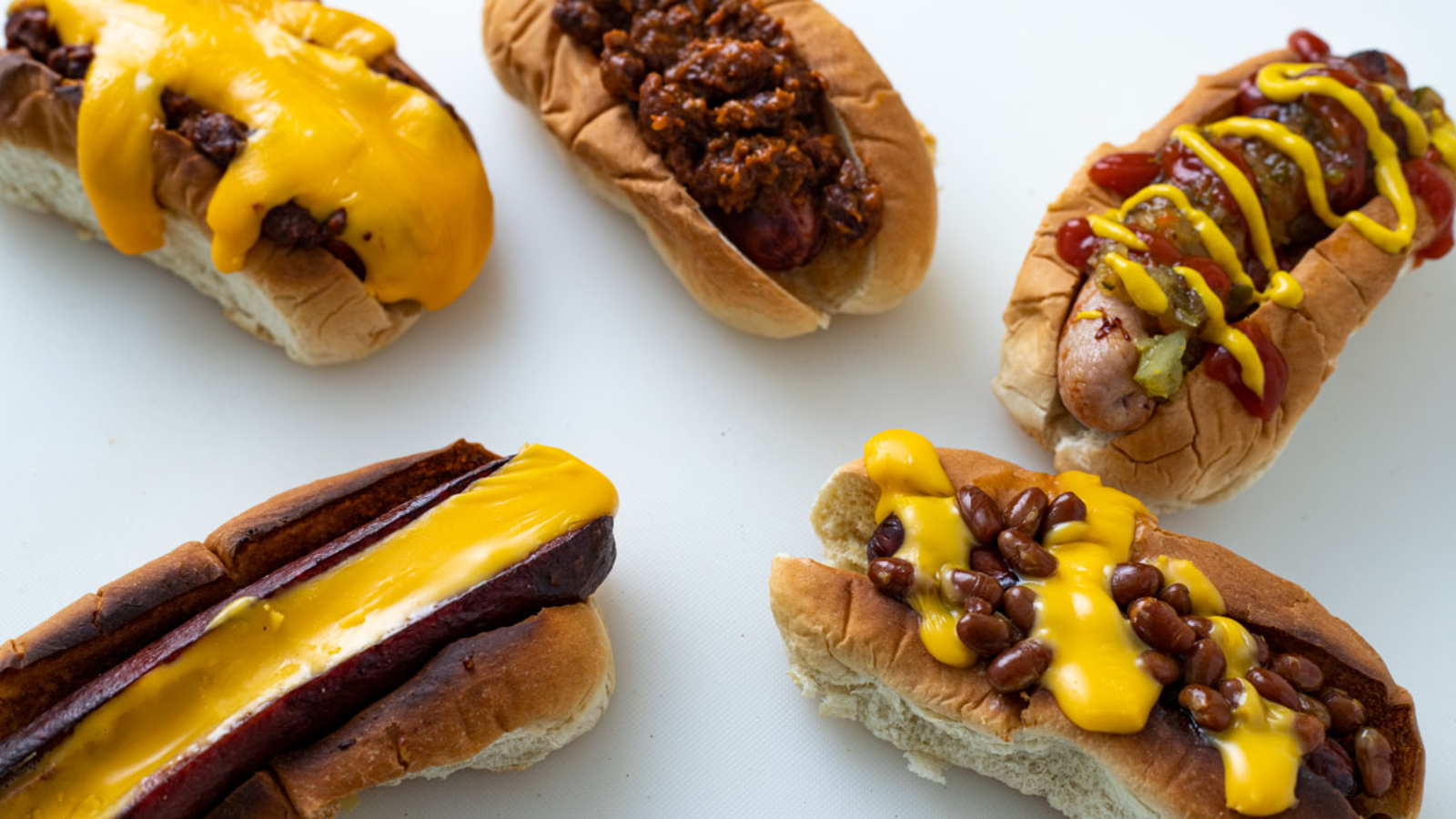 Hotdogs in a bun with sauce on top.
