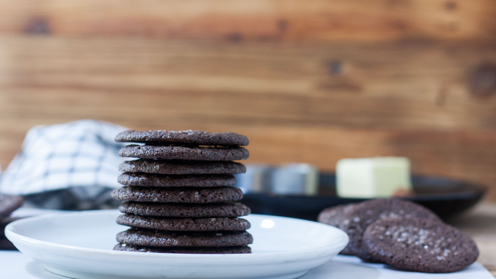 Stacked chocolate cookies on a plate.