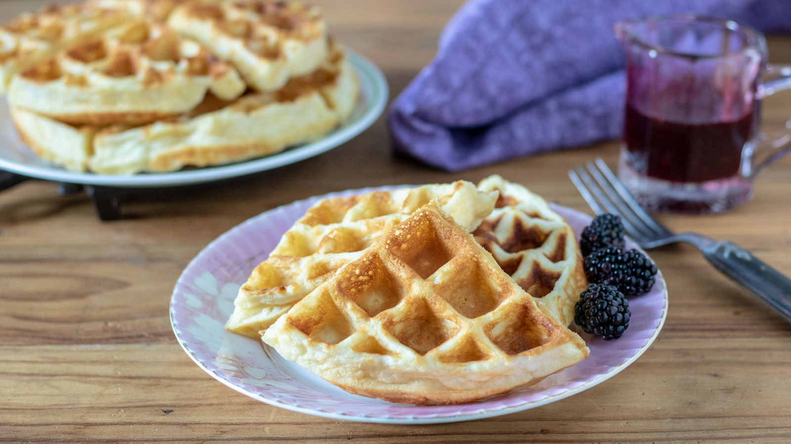 Two plates with waffles and blueberries.