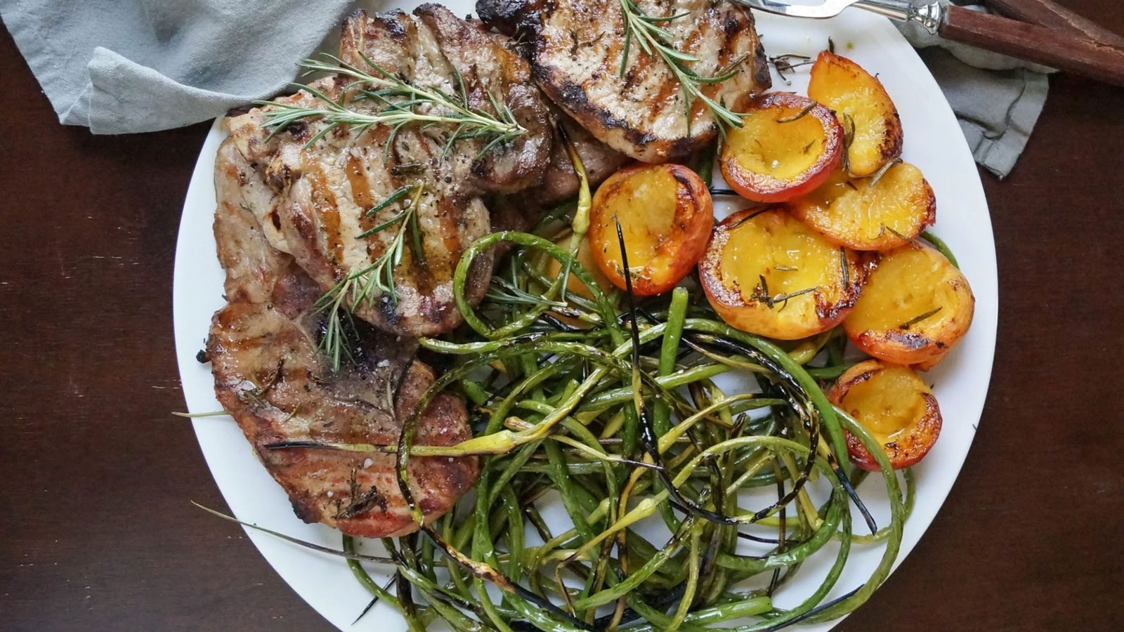 Grilled pork chops with garlic scapes and peaches.