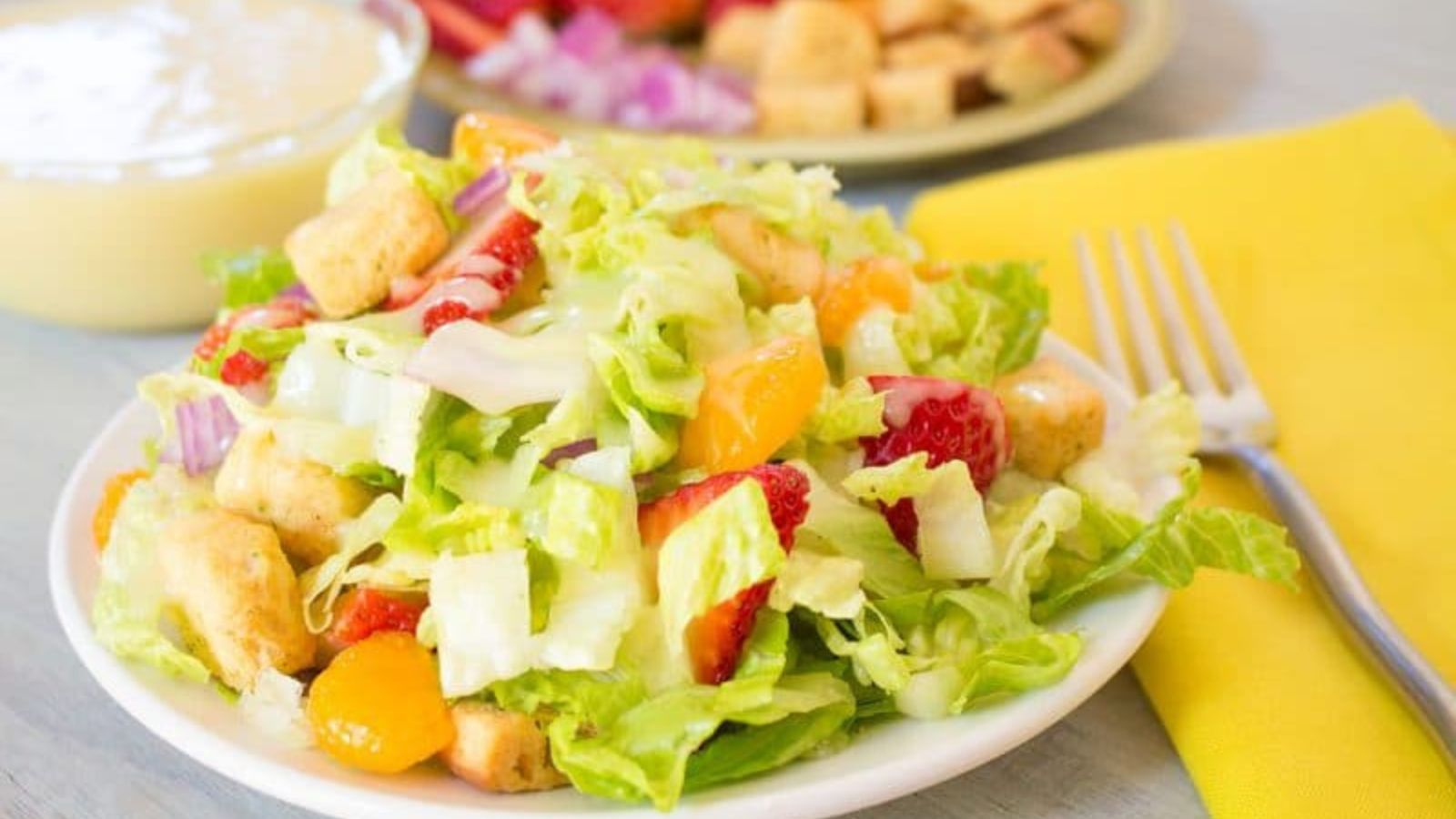 Plateful of salad showcasing lettuce, strawberries and chunks of citrus (mandarin).