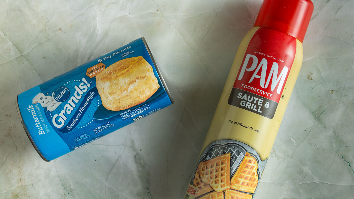 No-stick spray and Pillsbury Grands biscuit on a white board.