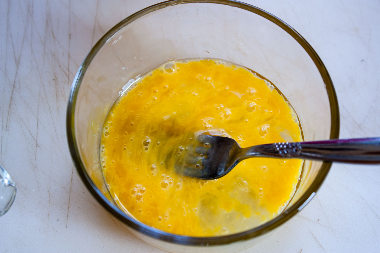 Eggs whisked in a bowl.