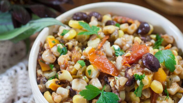 Colorful bowl of corn bean salsa topped with cilantro