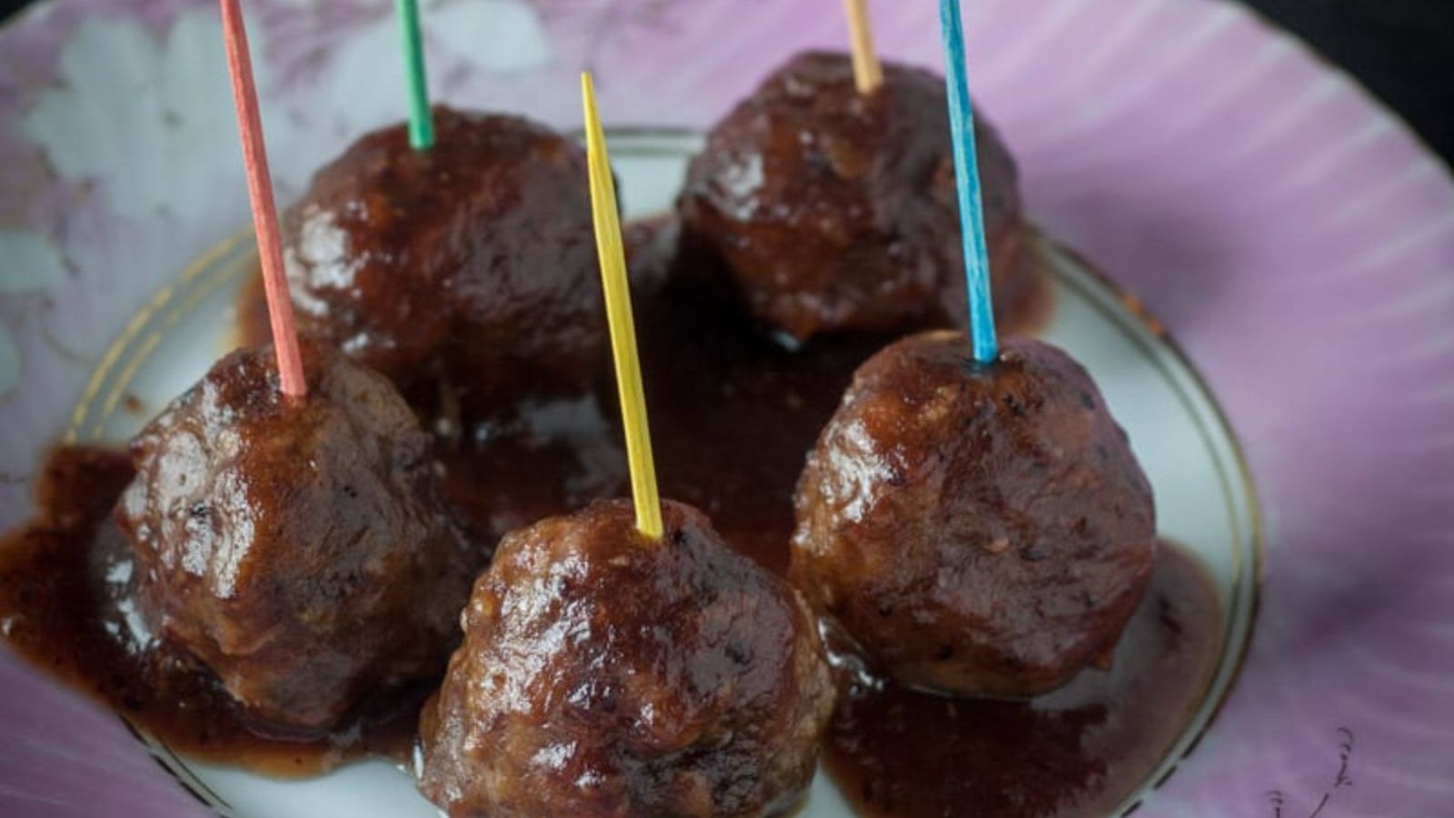 Close up of meatballs with colorful tootpicks in them.
